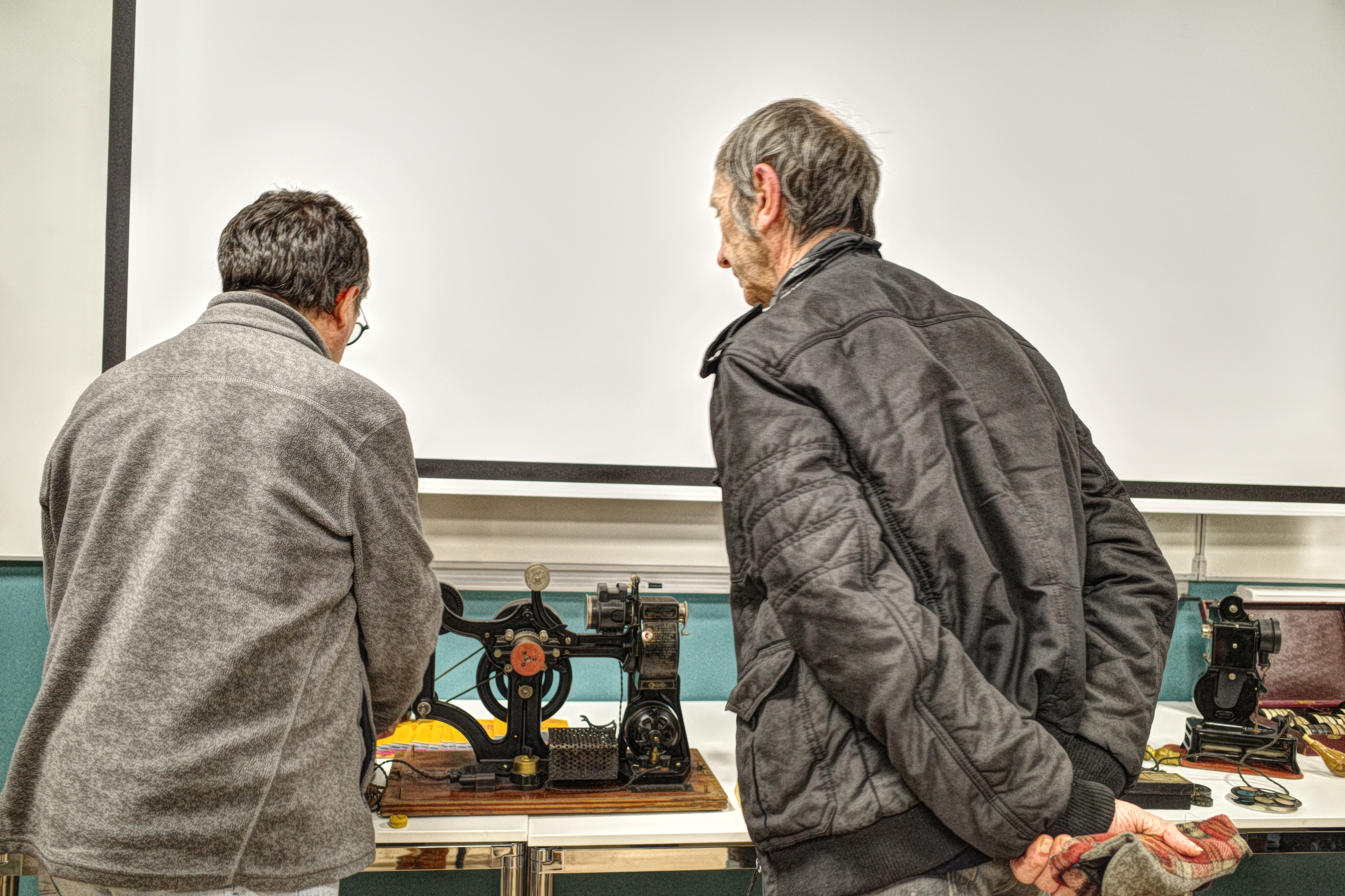 A l'issue de la conférence des spectateurs viennent admirer le matériel, ici le projecteur Pathé-Kok