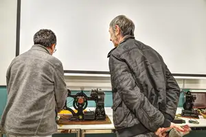 A l'issue de la conférence des spectateurs viennent admirer le matériel, ici le projecteur Pathé-Kok